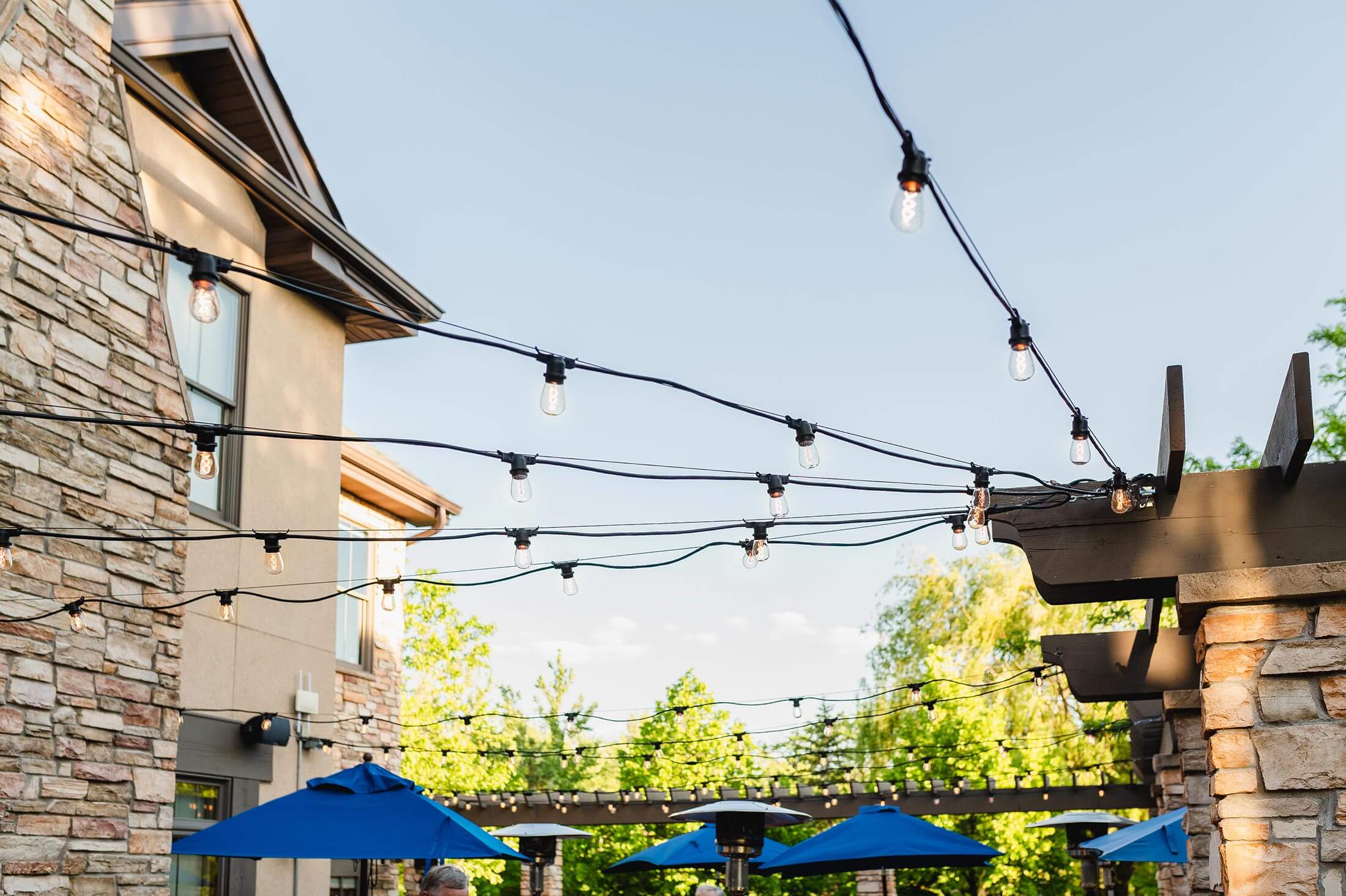 Blue umbrellas and patio lights at an outdoor restaurant